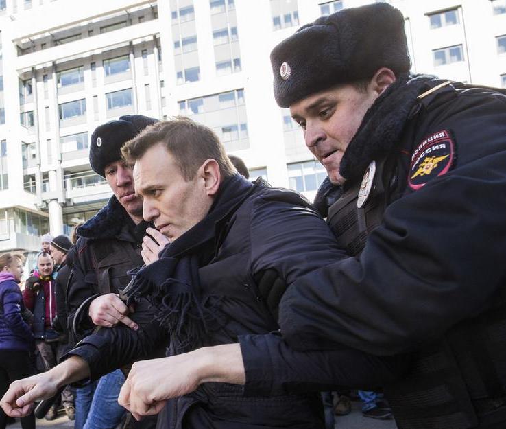 policja prowadzi mężczyznę na policję w celu przeszukania